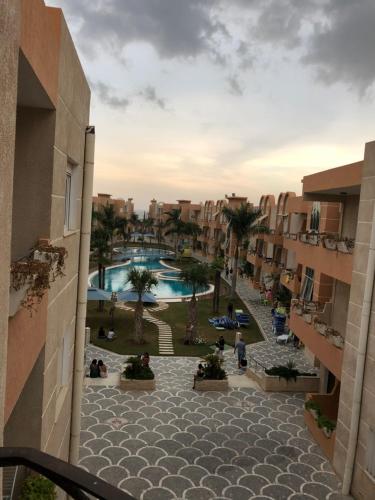 een balkon met uitzicht op een resort met een zwembad bij Dunes ressort chott Meriem in Sousse