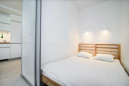 1 dormitorio con 1 cama y pared de cristal en #stayhere - Comfy & Stylish Studio with Green Patio close to Old Town, en Vilna