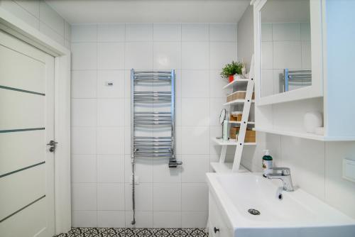 a white bathroom with a sink and a shower at #stayhere - Comfy & Stylish Studio with Green Patio close to Old Town in Vilnius