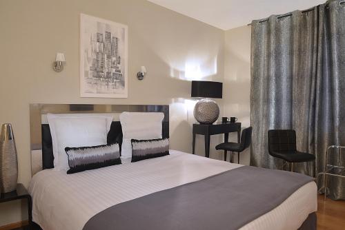 une chambre avec un grand lit avec deux oreillers dans l'établissement Logis L'hermitage, à Buzançais