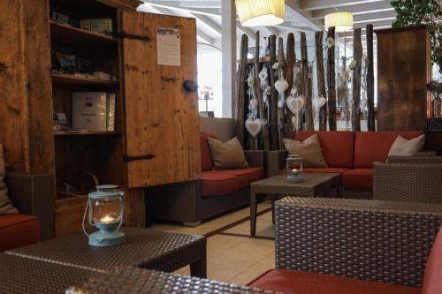 a restaurant with couches and tables and a candle at Hotel Weingarten in Appiano sulla Strada del Vino