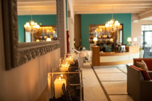 a room with candles and a mirror on a wall at Hotel Weingarten in Appiano sulla Strada del Vino