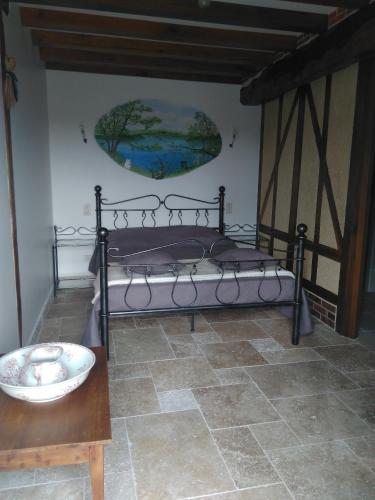 - un lit dans une chambre avec une table et un bol dans l'établissement Gîtes les Terriers, à Saint-Jean-Froidmentel