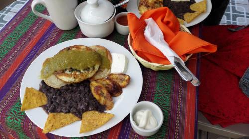 a white plate of food with beans and a sandwich at Cristales de Antigua Hotel Cristal in Antigua Guatemala