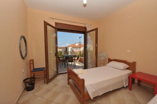 a bedroom with a bed and a balcony with a table at Marina Maisonette by RentalsPro Kallithea Halkidiki in Kallithea Halkidikis