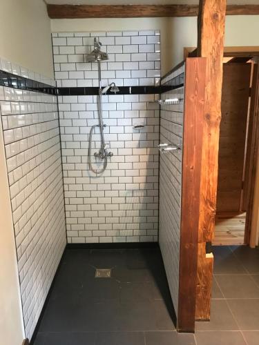 ein Bad mit einer Dusche und weißen Fliesen in der Unterkunft 72 Route Du Fry in Les Gets