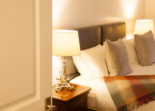 a bedroom with a bed with a lamp on a table at Dunperrogh in St. Andrews