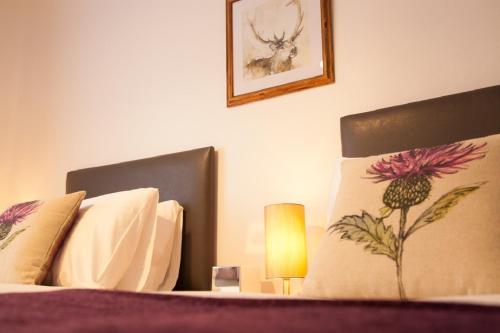 a bedroom with a bed with two pillows and a lamp at Dunperrogh in St. Andrews