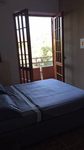 a bedroom with a bed and an open door at Villa DonnAnna in Cariati