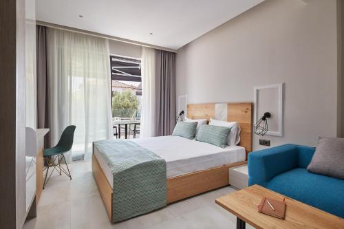 um quarto com uma cama e um sofá azul em Albatros Suites em Nea Vrasna