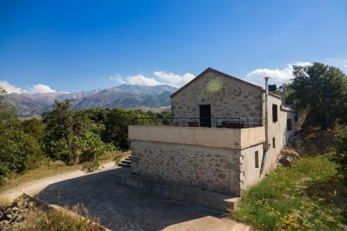 a building on a hill with mountains in the background at Lithari in Kámboi