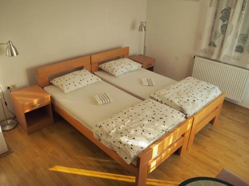 two twin beds in a room with wooden floors at Apartment Ivan-Experience 3 Bedrooms in Ljubuški