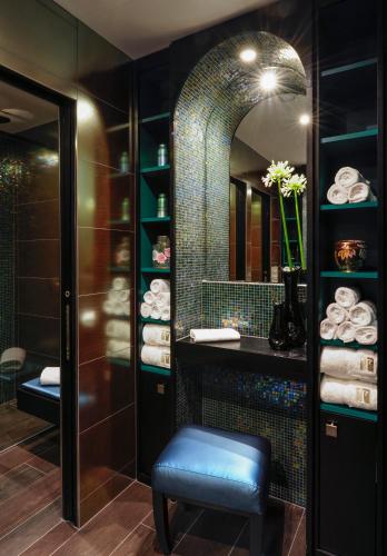 a bathroom with a stool and a mirror at Hôtel Tiffany by Fassbind in Geneva