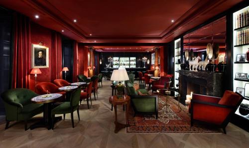 a bar with green and red chairs and tables at Hotel Sacher Salzburg in Salzburg