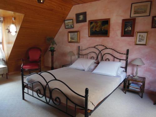 a bedroom with a large bed and a red chair at Ty An Eol in Saint-Évarzec