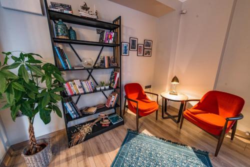 een woonkamer met 2 stoelen en een boekenplank bij Elia Hotel Cunda by Ortunc in Ayvalık