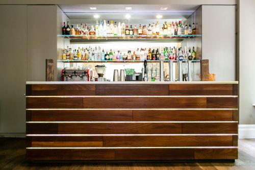 a bar at a restaurant with a shelf of drinks at The Green House in Bournemouth