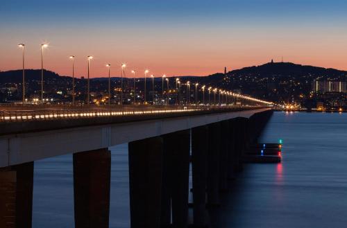 a bridge over the water with a city in the background at Dunperrogh in St. Andrews