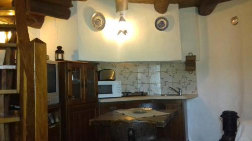a kitchen with a sink and a microwave on the wall at Cabeço dos Três Moinhos in Rio Maior