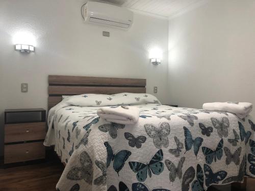 a bedroom with a bed with a blanket with butterflies on it at Residencial Victoria Said in Linares