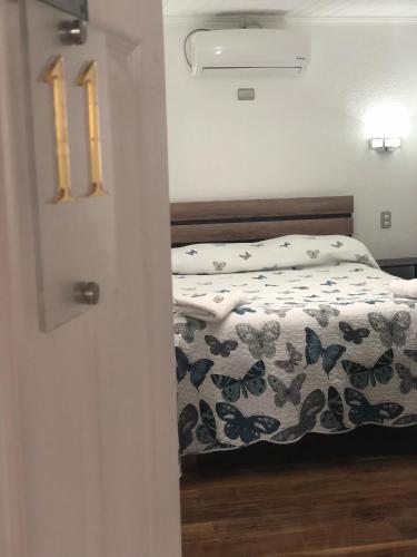 a bedroom with a bed with a floral comforter at Residencial Victoria Said in Linares