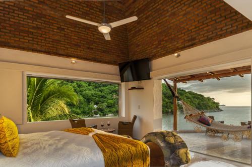a bedroom with a view of the ocean and a hammock at Villa Lala Boutique Hotel Adults Only in Puerto Vallarta