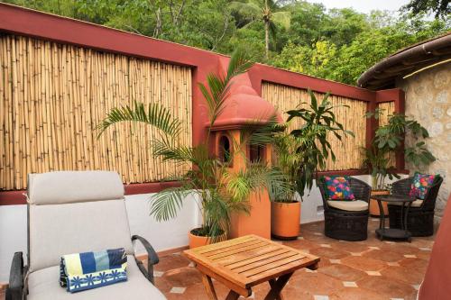 a patio with a table and chairs and a bench at Villa Lala Boutique Hotel Adults Only in Puerto Vallarta