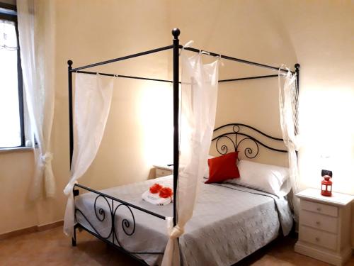 Un dormitorio con una cama con dosel y flores. en City life Pompeii -Suite King Deluxe en Pompeya