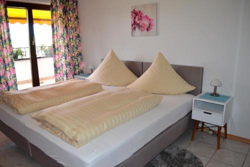 uma cama com duas almofadas num quarto em Rennbahn - Life Iffezheim; Wohnen mit Rennbahnblick em Iffezheim