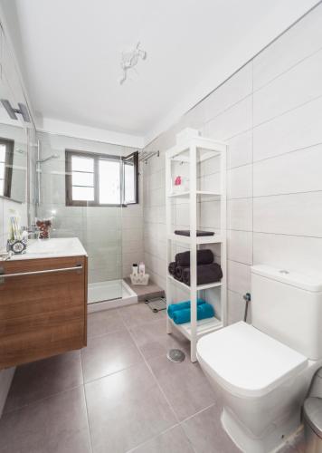 a bathroom with a toilet and a sink and a shower at Luxury Beach Apartments in Playa Honda