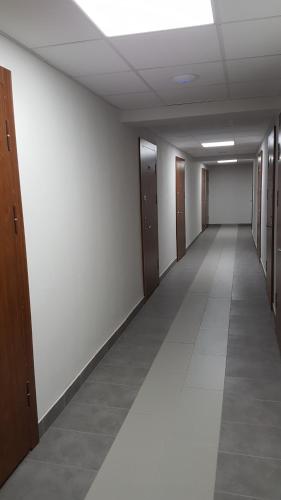 un corridoio vuoto di un edificio per uffici con porte in legno di Klaipeda Akro Studio a Klaipėda