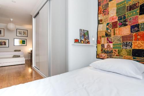 リスボンにあるLisbonSpot58の白いベッドとモザイクの壁が備わるベッドルーム1室が備わります。