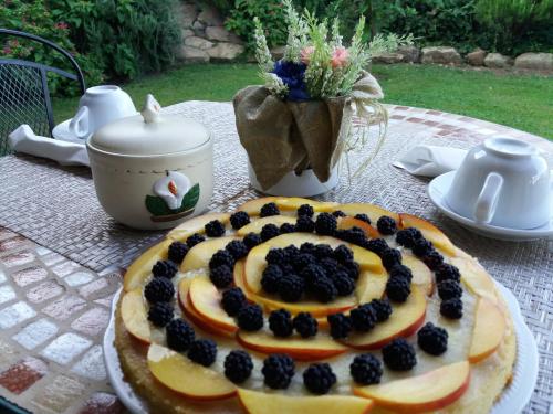 a cake with berries on top of it on a table at Agriturismo Colleverde Capalbio in Capalbio