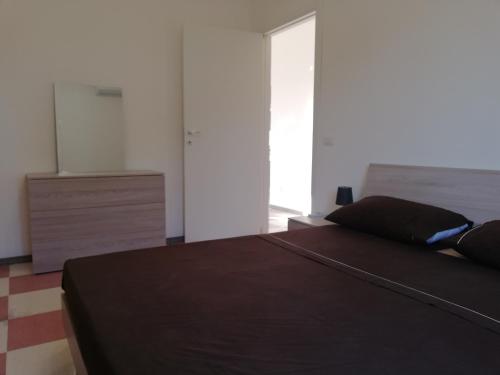 a bedroom with a brown bed and a dresser at New Rooms on The Beach in Pozzallo