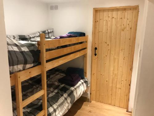 a bedroom with two bunk beds and a door at Plas Eryr apartment in Caernarfon