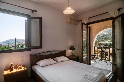 a bedroom with a bed and a large window at Olive green house in Agia Pelagia