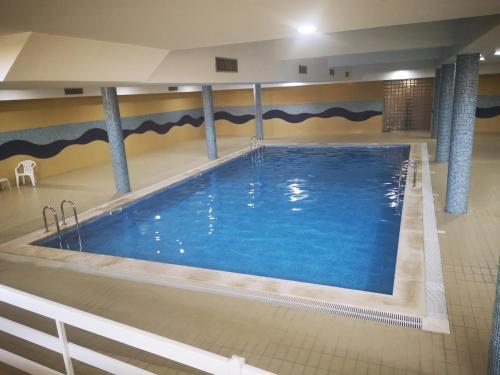 a large swimming pool with blue water in a building at Apartment Ericeira in Ericeira