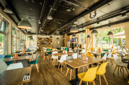 a restaurant with wooden tables and yellow chairs at PARK45 in Sopot