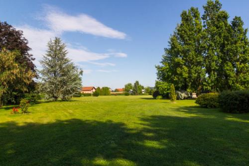 a large green field with trees in a yard at Airport room's Residence Garden in Velika Gorica