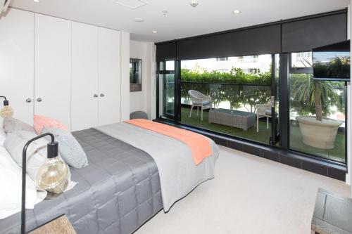 a bedroom with a large bed and a large window at Ocean Eleven 25 in Mount Maunganui
