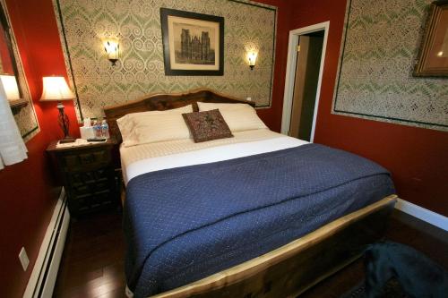 a bedroom with a large bed in a red room at Alpenhof Bed & Breakfast in Media