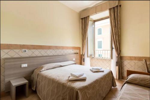 1 dormitorio con 1 cama con 2 toallas en Alex Romano, en Roma