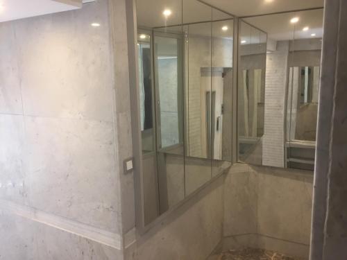 a bathroom with a shower with mirrors on the wall at Appartement Familial Emile Zola in Casablanca