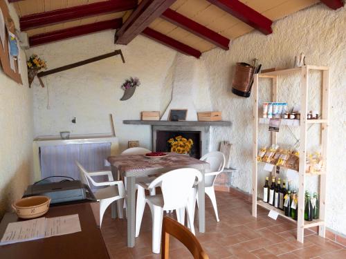 a dining room with a table and chairs and a fireplace at Poderino Bellavista in Castellina Marittima