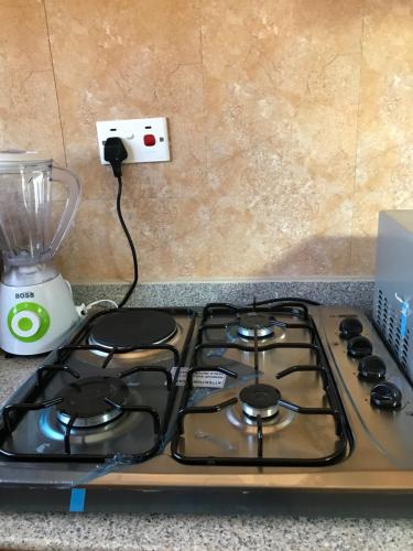 a stove top with a cord plugged into an electrical outlet at Chibuba Airport Accommodation in Dar es Salaam