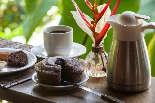 una mesa con una taza de café y un plato de pan en Dendê Loft, en Isla de Boipeba