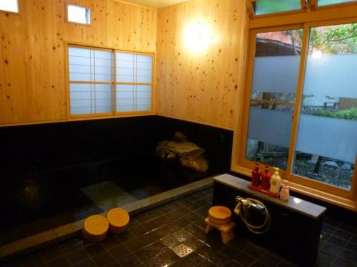 a bathroom with a large tub in a wooden room at Yudanaka Tawaraya Ryokan in Yamanouchi