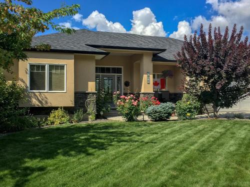 a house with a yard with green grass at Adela's Bed and Breakfast in West Kelowna
