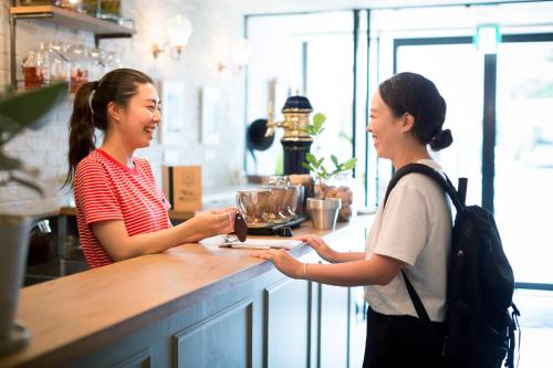 two women standing at a counter in a coffee shop at Hotel Pacific Kanazawa in Kanazawa