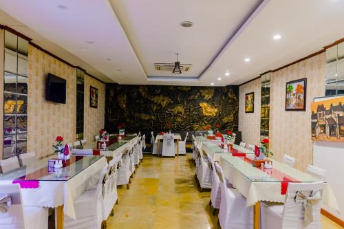a dining room with white tables and white chairs at A25 Hotel - 12 Ngô Sỹ Liên in Hanoi